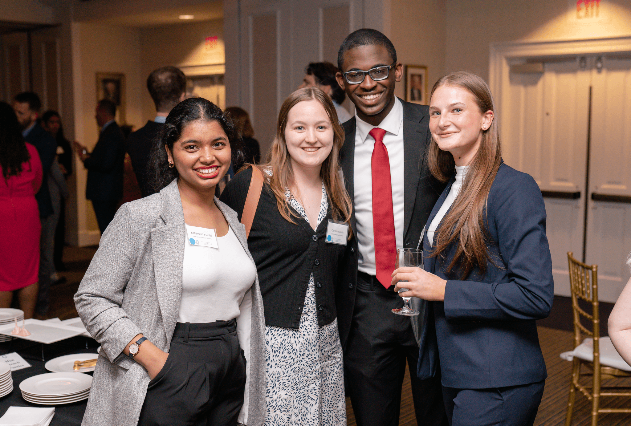 Devin smiling with a group of students at a formal event